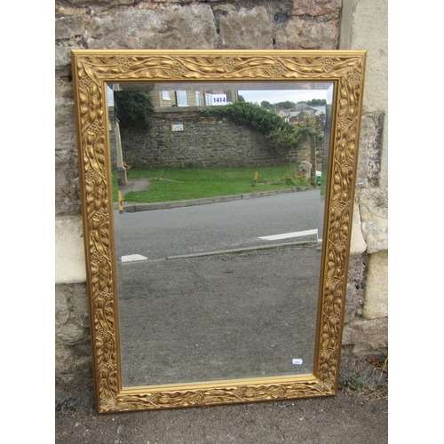 1414 - A gilt framed wall mirror with moulded foliate and floral borders enclosing a bevelled plate, 90 x 6... 