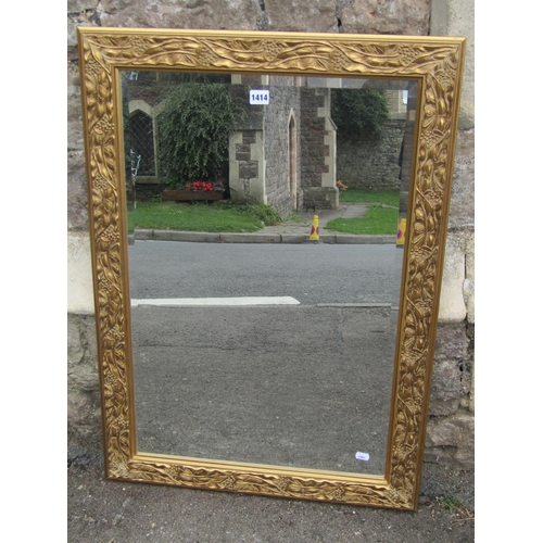 1414 - A gilt framed wall mirror with moulded foliate and floral borders enclosing a bevelled plate, 90 x 6... 