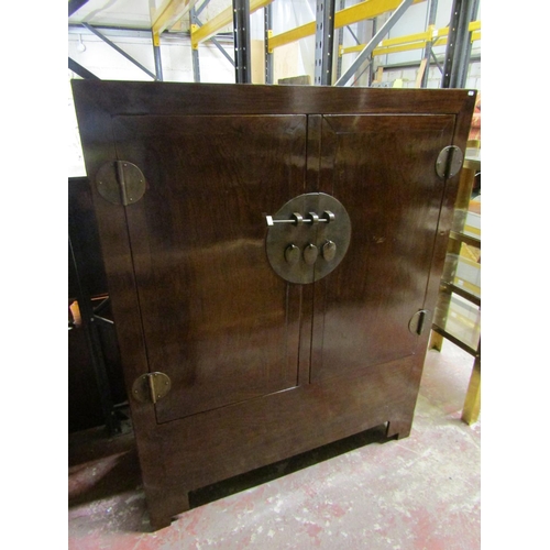 1552 - A 20th century Chinese lacquered elm hall cupboard with brass lock plate and hinges to panelled door... 