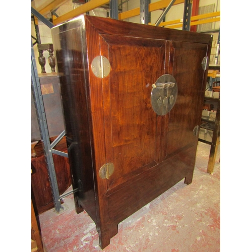 1552 - A 20th century Chinese lacquered elm hall cupboard with brass lock plate and hinges to panelled door... 