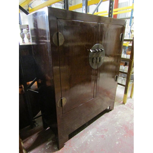 1552 - A 20th century Chinese lacquered elm hall cupboard with brass lock plate and hinges to panelled door... 