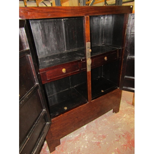 1552 - A 20th century Chinese lacquered elm hall cupboard with brass lock plate and hinges to panelled door... 