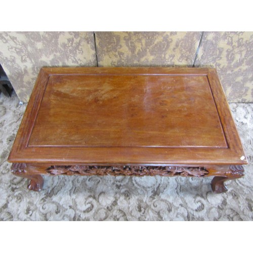 1227 - A Chinese carved hardwood low occasional/coffee table with bevelled top above a carved and pierced f... 