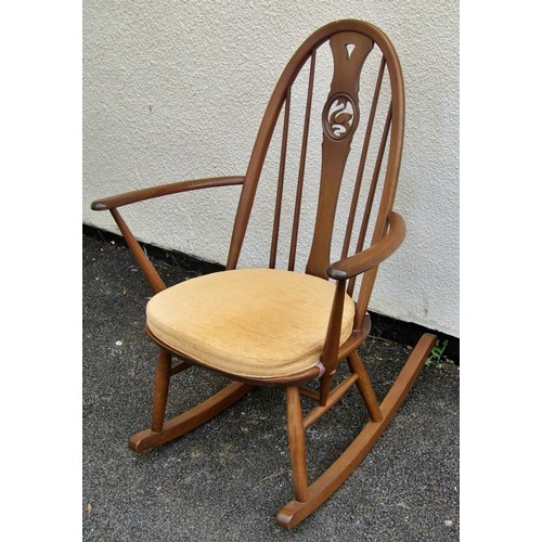 1578 - A Ercol rocking elbow chair with swan carved back splat