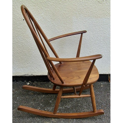 1578 - A Ercol rocking elbow chair with swan carved back splat