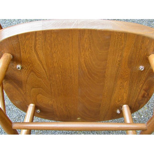 1578 - A Ercol rocking elbow chair with swan carved back splat