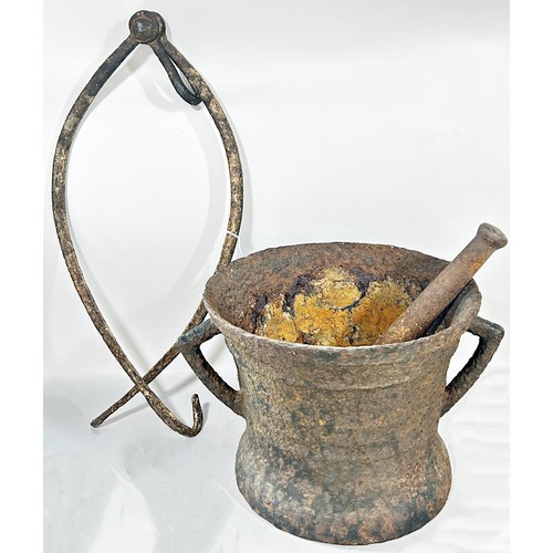 555 - A substantial early cast iron pestle and mortar 26cm diameter, together with  pair of iron grips