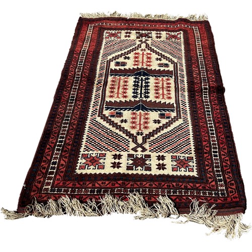 1743 - A Kazak type carpet with an elongated central panel on a cream ground, 180cm x 110cm approximately