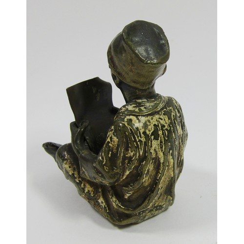 390 - A cold painted bronze figure of a seated boy reading