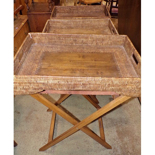 1205 - Three similar Butler’s woven cane trays / occasional tables, all with folding stands, with labels Ta... 