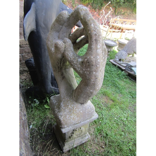 1048 - A large decorative weathered reconstituted stone garden ornament in the form of hands held together,... 