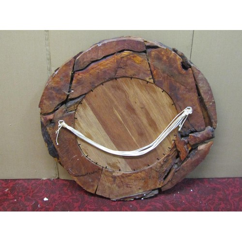 1423 - A rustic timber framed wall mirror of circular form with stained finish, 70 cm diameter.