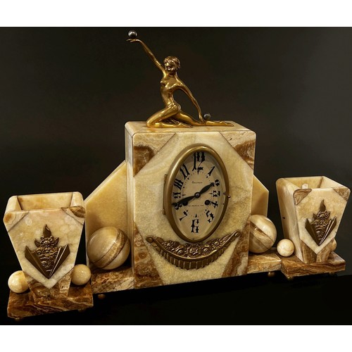 412 - An art deco clock garniture in onyx with oval dial surmounted by a female in out stretched kneeling ... 