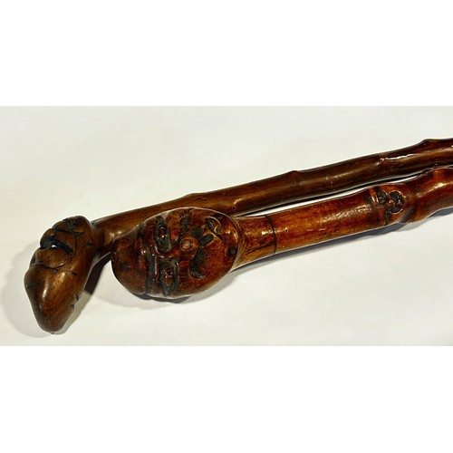 426 - Two walking sticks with carved wood human head handles.