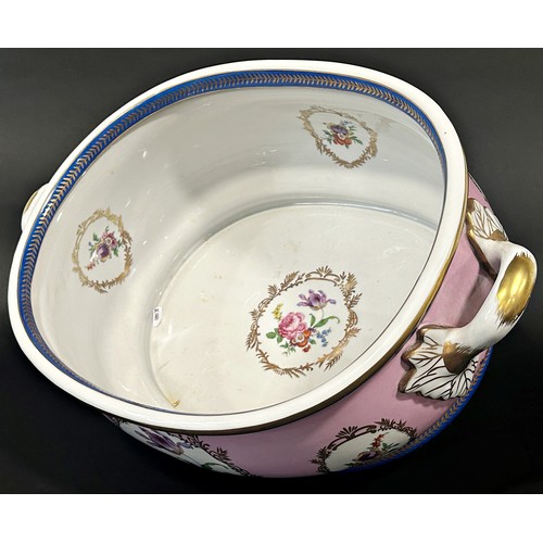 5 - A large ceramic foot bath with floral bouquet detail upon a pink ground within blue and gilt banded ... 