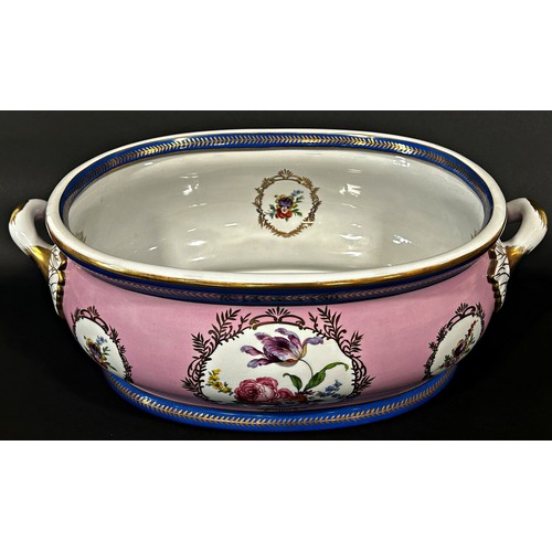 5 - A large ceramic foot bath with floral bouquet detail upon a pink ground within blue and gilt banded ... 