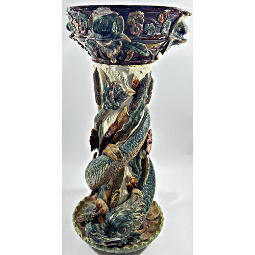 74 - A 19th century majolica jardinere stand, the column entwined by dolphins and bullrushes, 72cm high