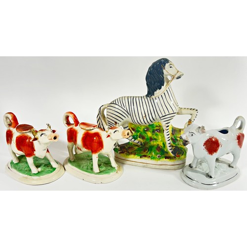 90 - Three 19th century Staffordshire cow creamers and a further Staffordshire zebra