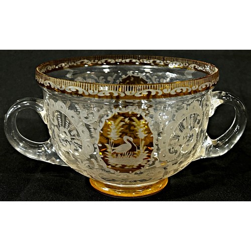 167 - A Bohemian double handled engraved glass bowl with amber panels and rim, 19cm diam max x 10cm high.