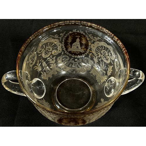 167 - A Bohemian double handled engraved glass bowl with amber panels and rim, 19cm diam max x 10cm high.