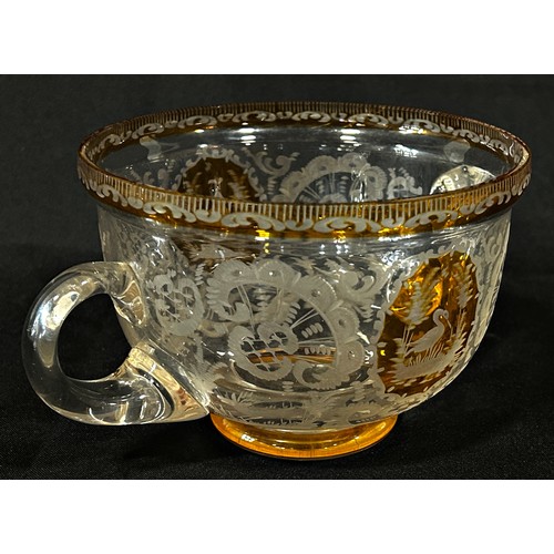 167 - A Bohemian double handled engraved glass bowl with amber panels and rim, 19cm diam max x 10cm high.