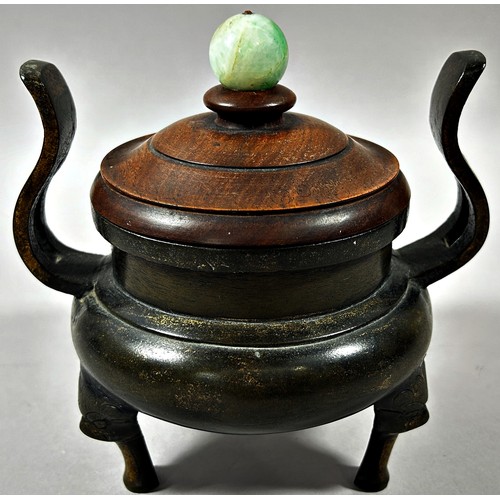 71 - Chinese bronze twin handled censor, raised on tripod supports, with turned hardwood cover and polish... 