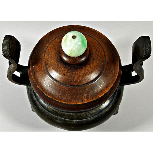 71 - Chinese bronze twin handled censor, raised on tripod supports, with turned hardwood cover and polish... 