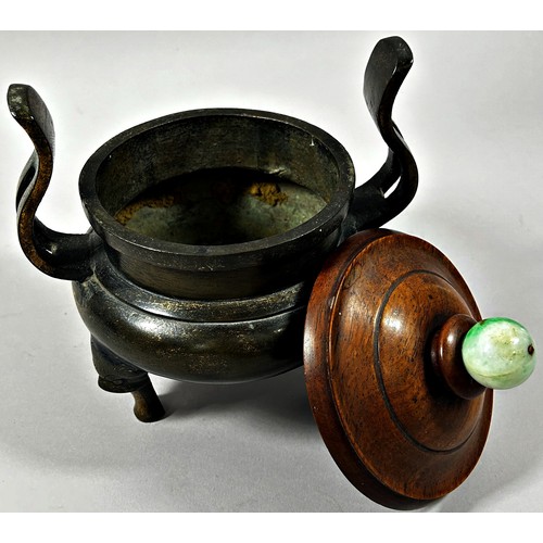 71 - Chinese bronze twin handled censor, raised on tripod supports, with turned hardwood cover and polish... 