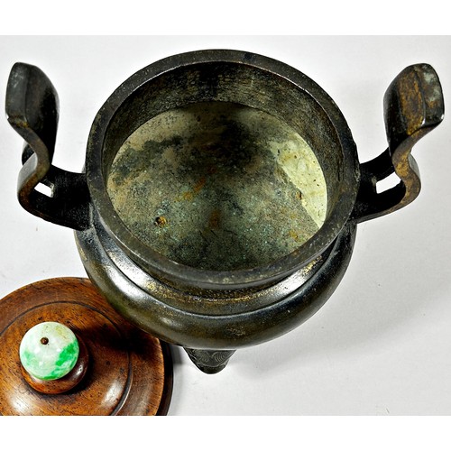 71 - Chinese bronze twin handled censor, raised on tripod supports, with turned hardwood cover and polish... 