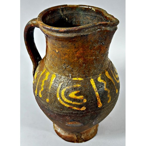 124 - An early pottery jug with loop handle and slipware detail, 19cm high