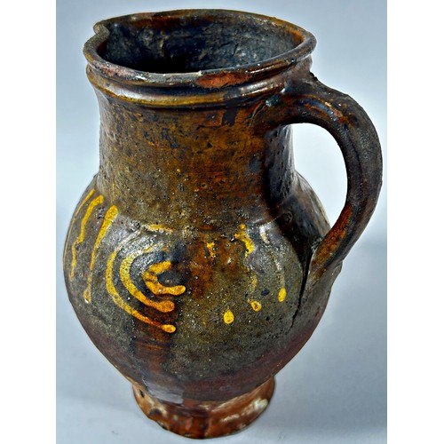 124 - An early pottery jug with loop handle and slipware detail, 19cm high