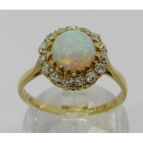 335 - Early 20th century 18ct cabochon opal and diamond cluster ring, the deep cabochon opal 3mm H x 6.5 d... 