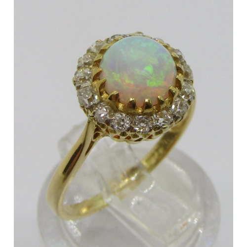 335 - Early 20th century 18ct cabochon opal and diamond cluster ring, the deep cabochon opal 3mm H x 6.5 d... 