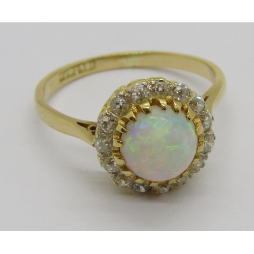 335 - Early 20th century 18ct cabochon opal and diamond cluster ring, the deep cabochon opal 3mm H x 6.5 d... 