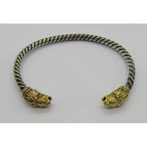 351 - Italian twisted white metal torque bangle with yellow metal lion head terminals, 24.6g