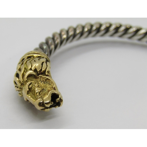 351 - Italian twisted white metal torque bangle with yellow metal lion head terminals, 24.6g