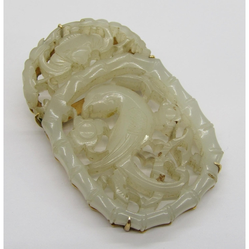 374 - 14k carved jade panel brooch depicting an exotic bird amidst foliage, stamped 'T.H. 585 14K' to reve... 