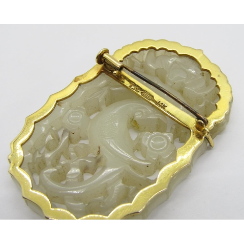 374 - 14k carved jade panel brooch depicting an exotic bird amidst foliage, stamped 'T.H. 585 14K' to reve... 