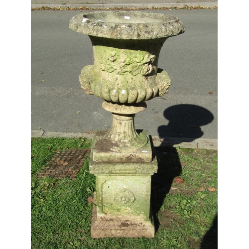 1001 - A weathered cast composition stone campana shaped garden urn with flared egg and dart rim, lobbed bo... 