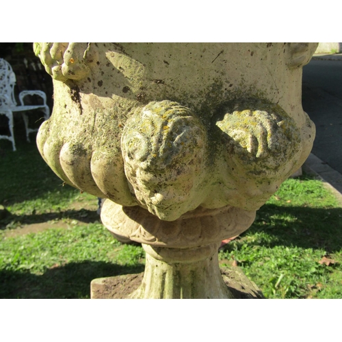 1001 - A weathered cast composition stone campana shaped garden urn with flared egg and dart rim, lobbed bo... 