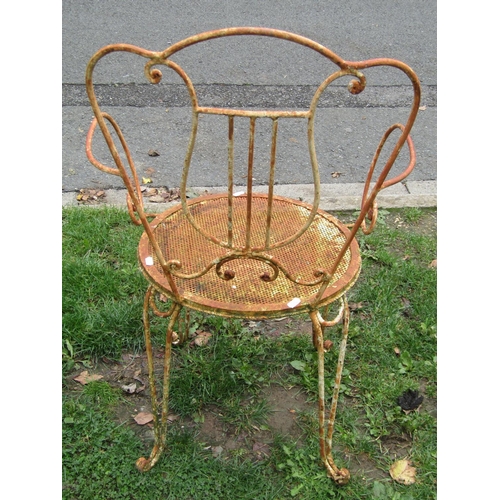 1005 - A set of four decorative weathered ironwork garden chairs the open scrollwork frames with lyre shape... 