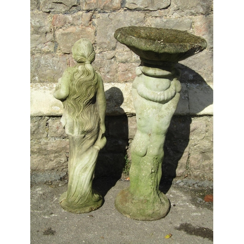 1012 - A weathered two sectional cast composition stone bird bath, the pedestal in the form of a standing c... 