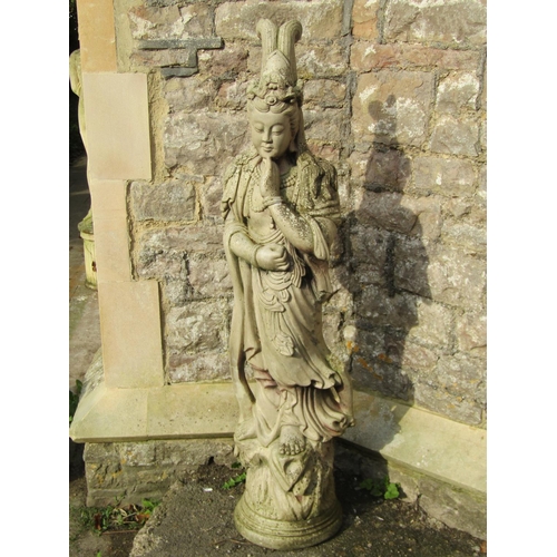 1028 - A weathered cast composition stone garden statue in the form of a standing oriental female in ceremo... 