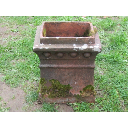 1034 - A weathered Victorian terracotta chimney pot of rectangular tapered form with repeating patterned fr... 