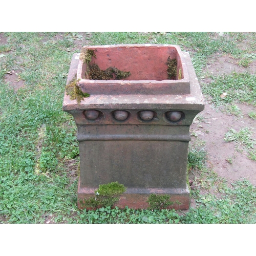 1034 - A weathered Victorian terracotta chimney pot of rectangular tapered form with repeating patterned fr... 