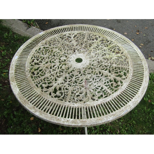 1044 - A weathered cream painted cast aluminium garden terrace table of circular form with decorative pierc... 