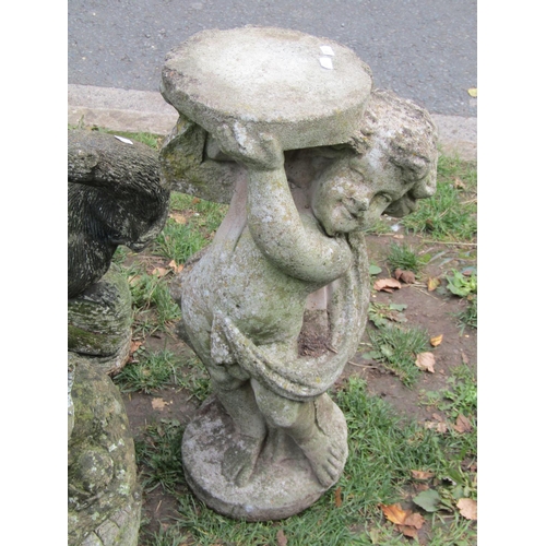 1053 - A weathered two sectional bird bath of square tapered and stepped form, a further weathered cherub p... 