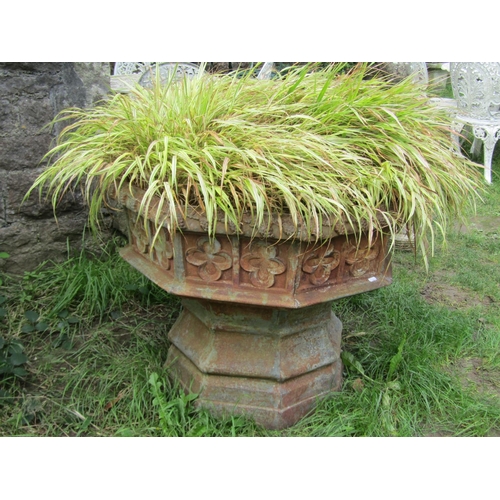 1058 - A large weathered cast iron font/ planter of octagonal form with gothic tracery detail (planted), 68... 