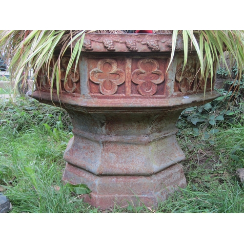 1058 - A large weathered cast iron font/ planter of octagonal form with gothic tracery detail (planted), 68... 