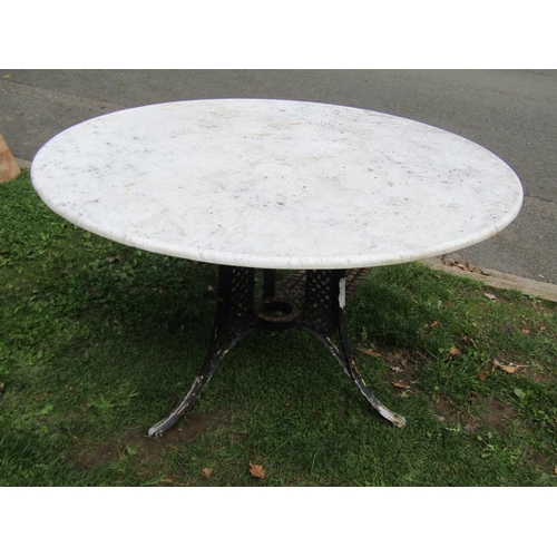 1059 - A weathered garden table the overhanging circular marble top 120 cm diameter raised on a swept cast ... 